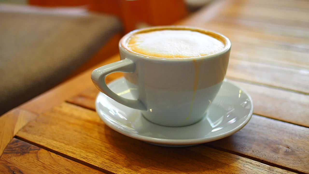 una taza de capuchino sobre una mesa de madera