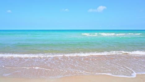 ocean waves wash up on the golden sand of a tropical beach