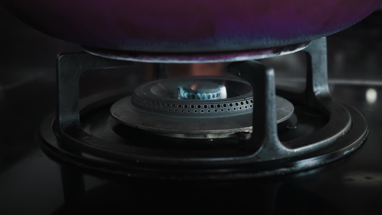 부에서 파란색과 빨간색으로 불타는 불꽃이 있는 검은색 가스 스토브의 비디오