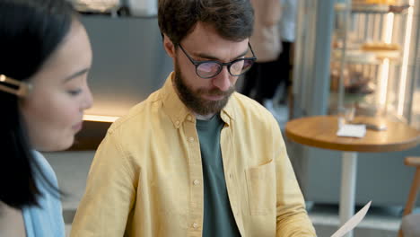 a man with glasses interviews an young woman for a job