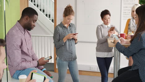 diverse group of business people using smart phone touch screen digital device to access cloud computing social media app for connected data sharing