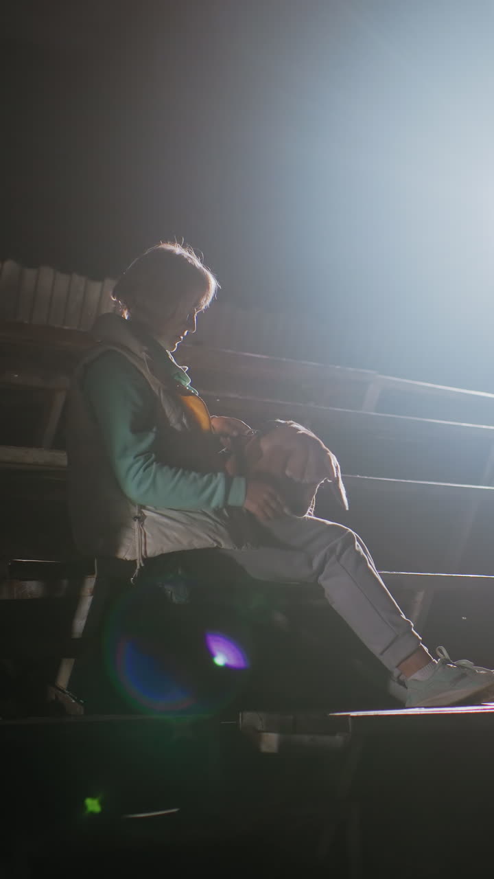Persona concentrada en las gradas preparándose el casco, ajustándose el chaleco y atándose las zapatillas con el brillo tenue de la tranquilidad entre bastidores, fuerte neblina de foco, ritual paciente antes de la actuación, energía tranquila y decidida, cinematográfico.