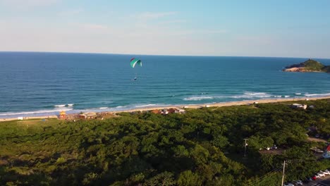 Paragliding-over-the-coastline-of-Florianopolis,-Brazil,-drone-view
