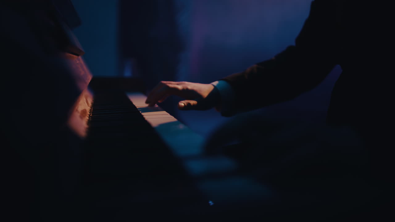 Person Playing Piano in Dark Room