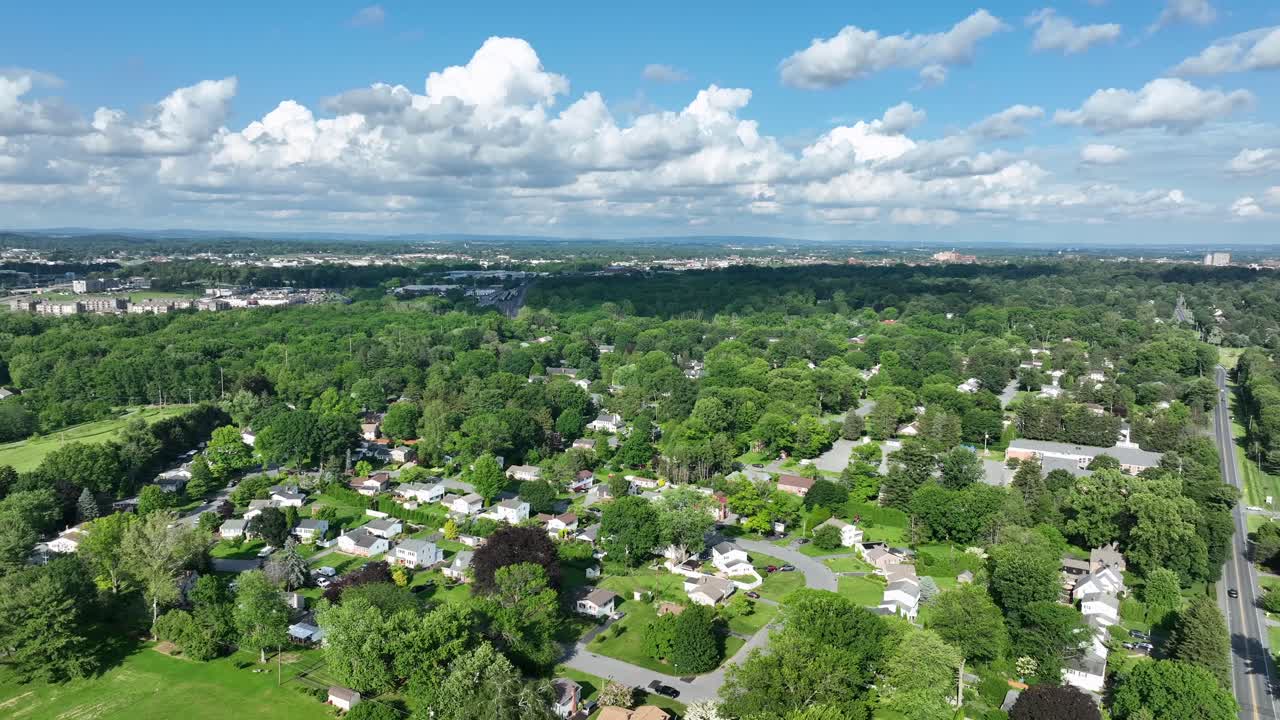 Zona residenziale verde e lussureggiante con case tra alberi verdi. Giornata di sole con nuvole nel cielo. Ampia ripresa aerea. Lancaster, Pennsylvania.