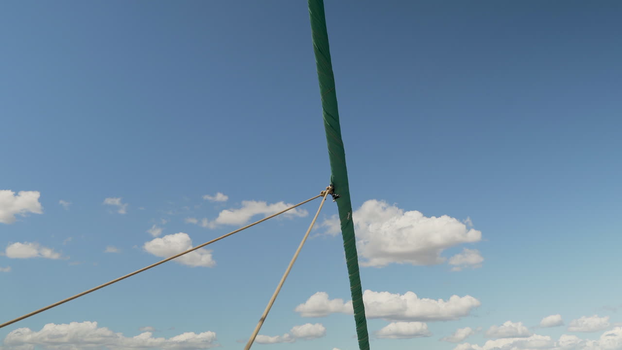Sailboat sail being furrowed during navigation on a sunny summer day