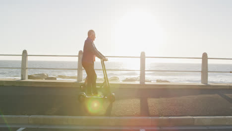 senior couple using electronic scooters alongside beach