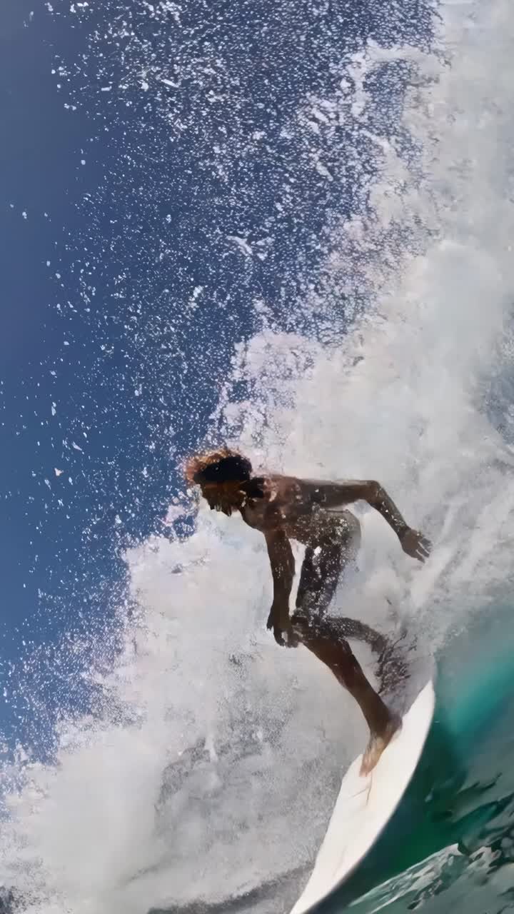 Professional surfer riding a powerful ocean wave on a bright sunny day, demonstrating impressive balance and skill while engaging in the exhilarating sport of surfing