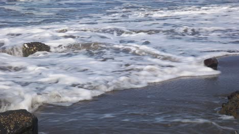 Nahaufnahme-Von-Wellen-An-Einem-Felsigen-Strand-Während-Des-Tages