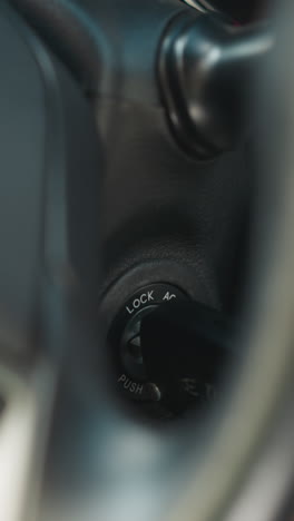 female hand with red nails turns on ignition key to crank engine of automobile. young woman starts car getting ready to drive closeup soft focus