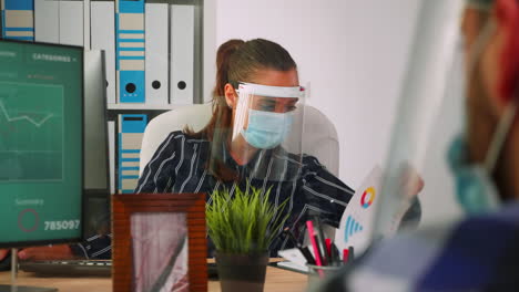 empresario con máscara de rostro discutiendo con su socio comercial