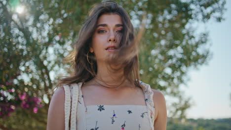 mujer posando árboles vegetación retrato de fondo. chica sexy tocando el cabello ventoso