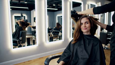 woman getting her hair blow-dried at a modern salon