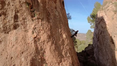 Hombre-Escalada-En-Roca-Vista-Aérea-Del-Deportista-Rappel-Montaña-En-La-Panocha,-El-Valle-Murcia,-España-Mujer-Rapel-Bajando-Una-Montaña-Escalando-Una-Gran-Roca