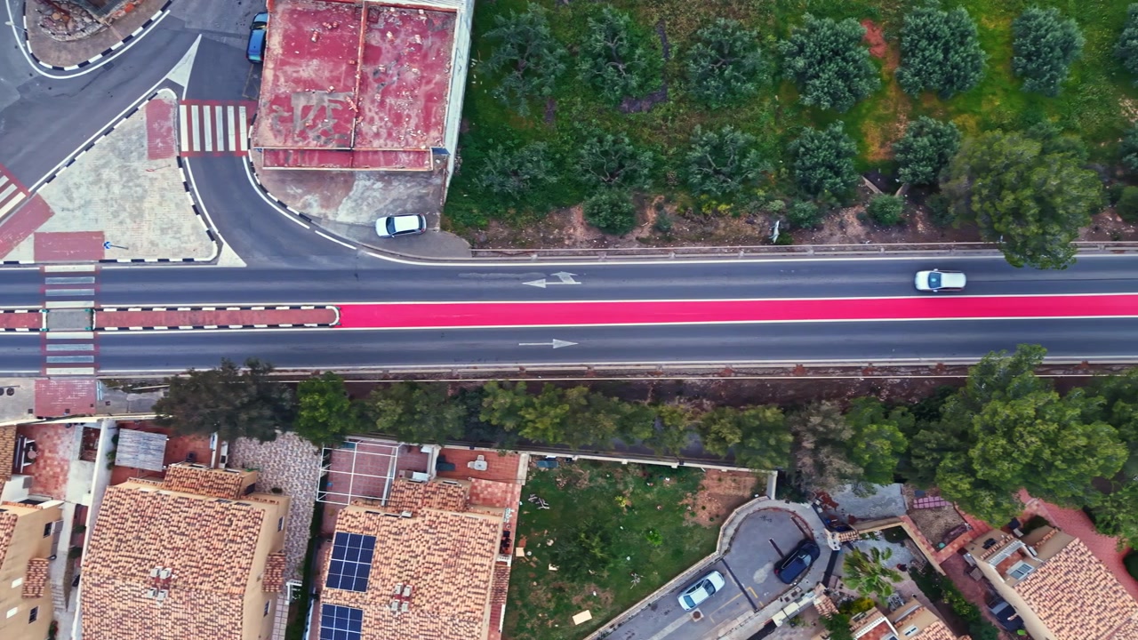 Incrocio stradale visto dall'alto con edifici, alberi e auto nelle vicinanze, di giorno, in un centro abitato.
