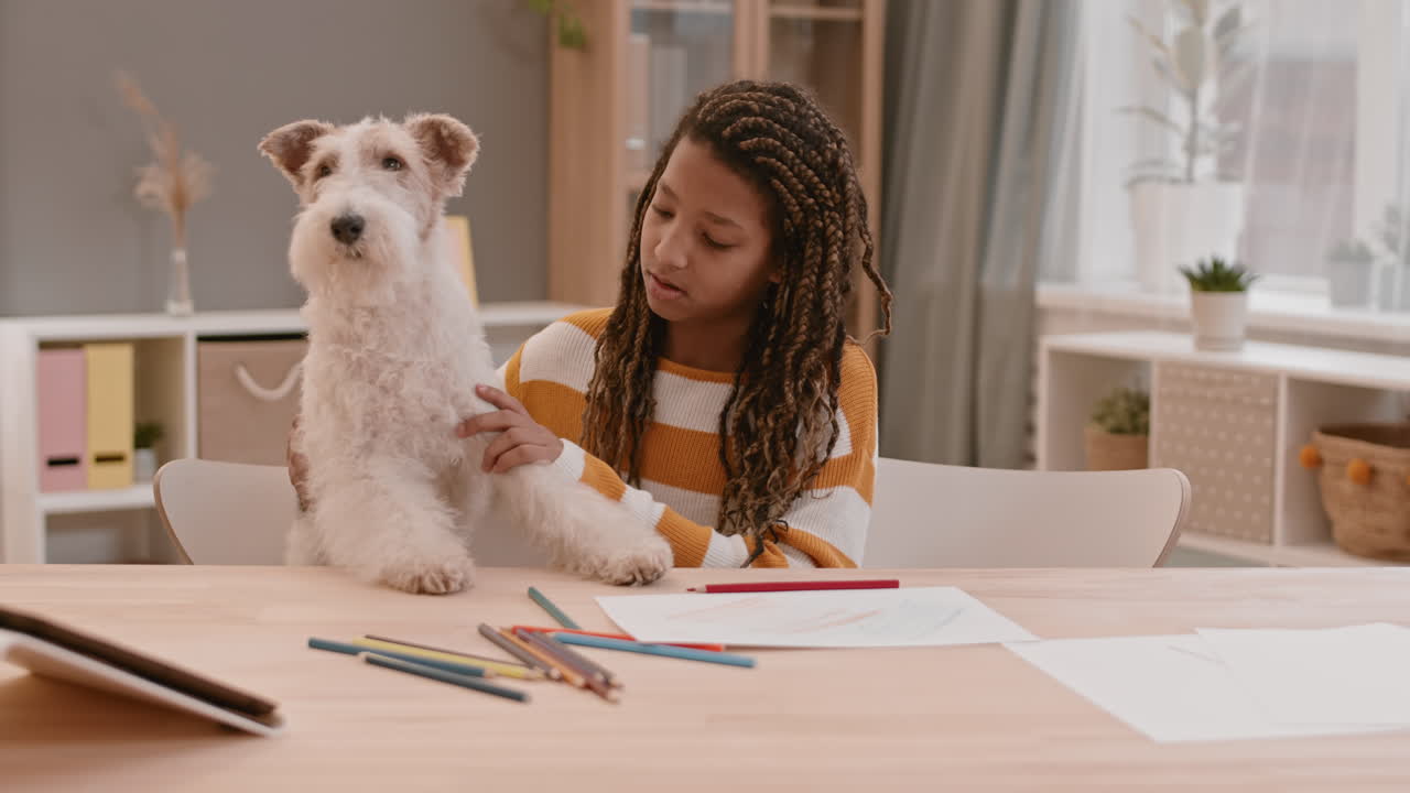 책상 에 앉아 있는 소녀와 개