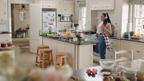 happy overweight teenage girl dancing in kitchen having fun celebrating weekend performing funny dance moves listening to music wearing headphones