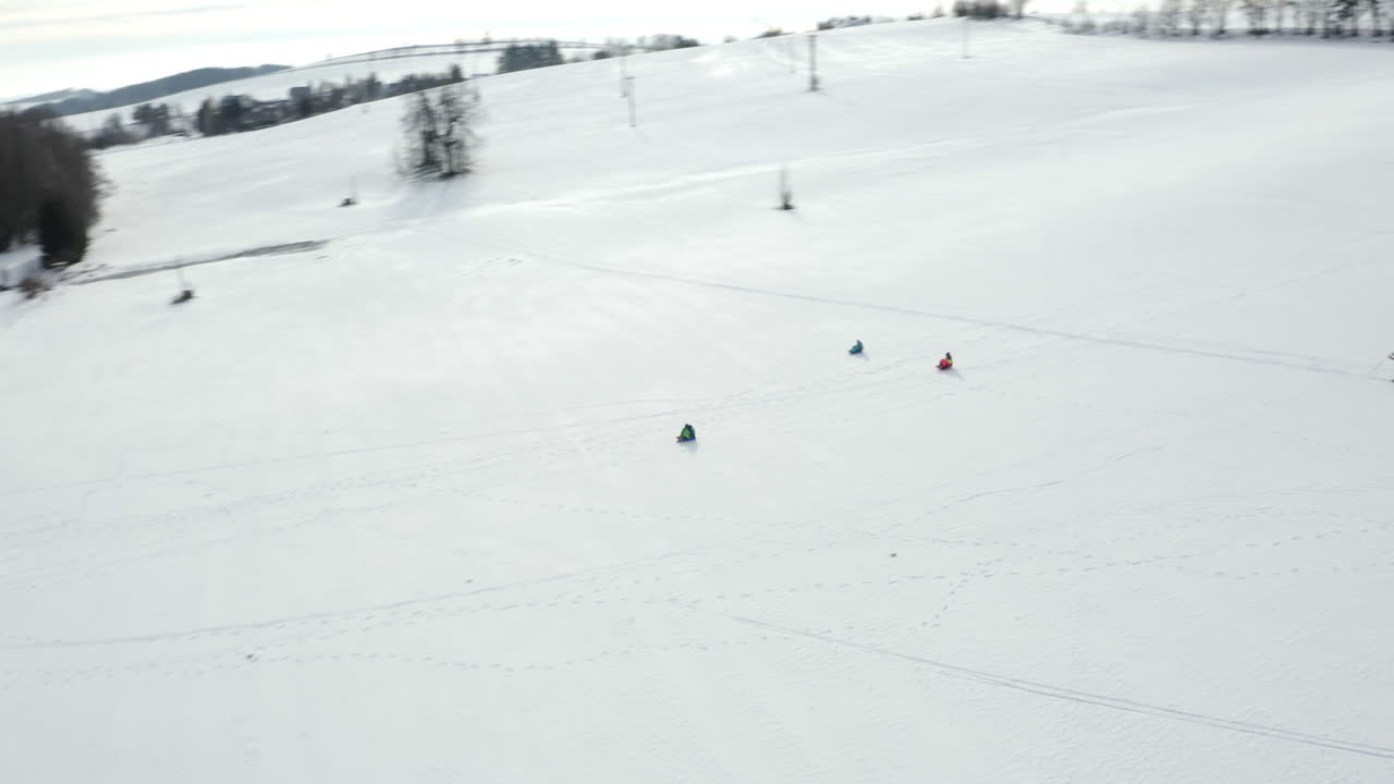 toma aérea de personas en trineo y esquiando en un campamento de esquí de invierno, paisaje cubierto de nieve