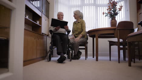elderly couple reading together at home