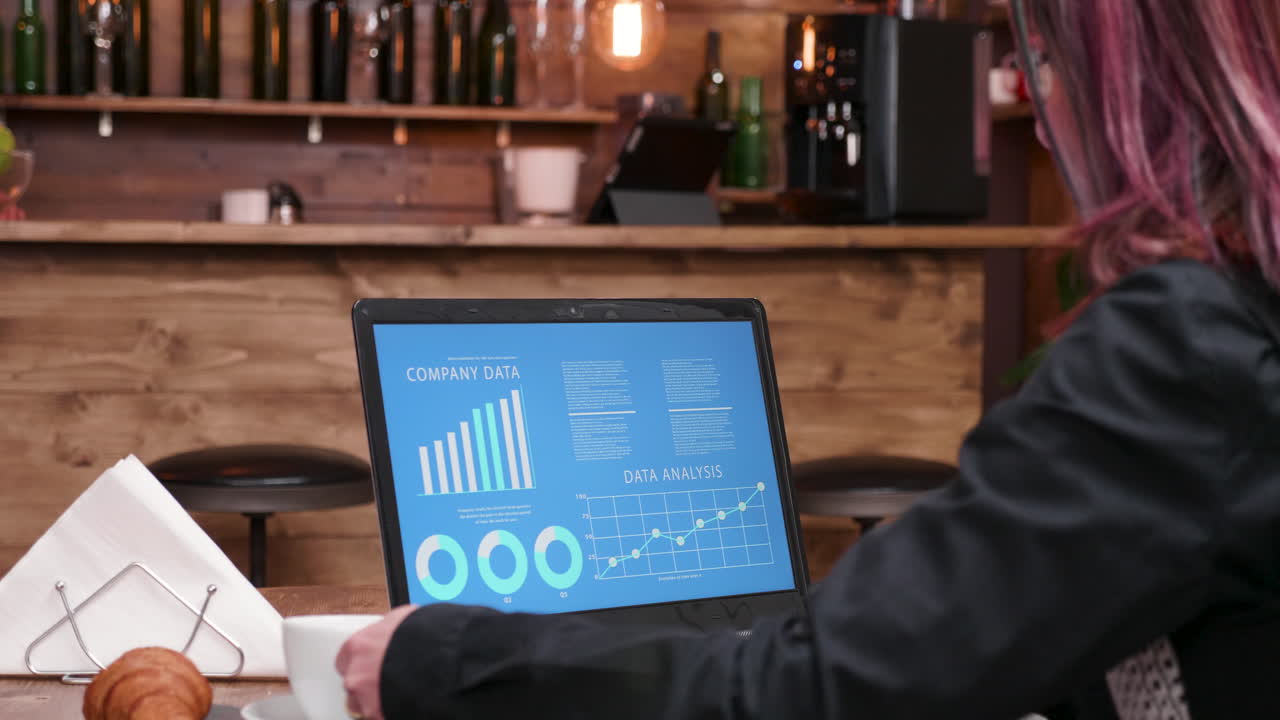 mujer trabajando en una computadora portátil en un café