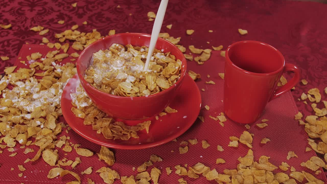 Milk splashes dramatically as it’s poured into a bowl of cereal, turning breakfast into a playful, chaotic scene