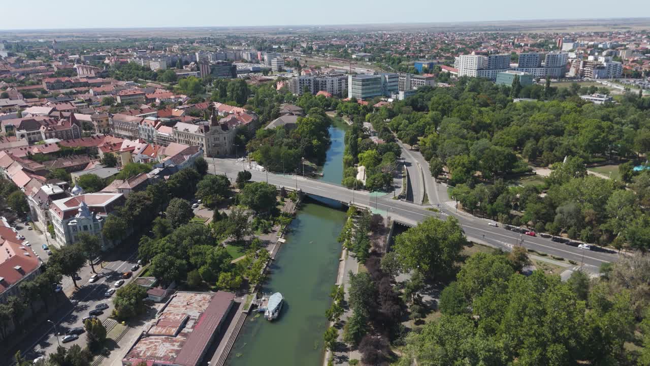 Scenic aerial shot showing the Bega River, bridge, and surrounding urban landscape of Timisoara from above