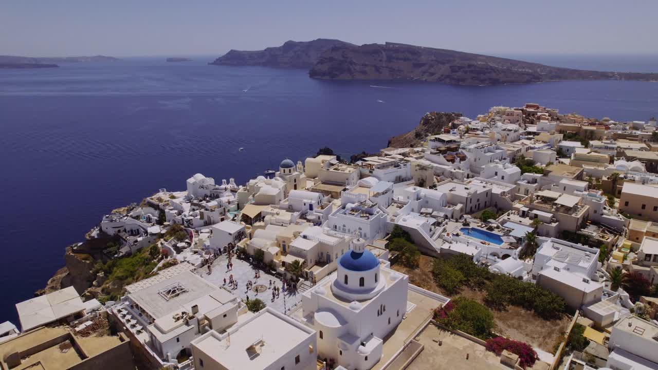Panoramic view of Santorini, Greece, with white houses and blue-domed churches overlooking the Aegean Sea