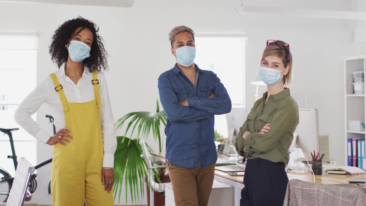 compañeros de oficina con máscaras en la oficina