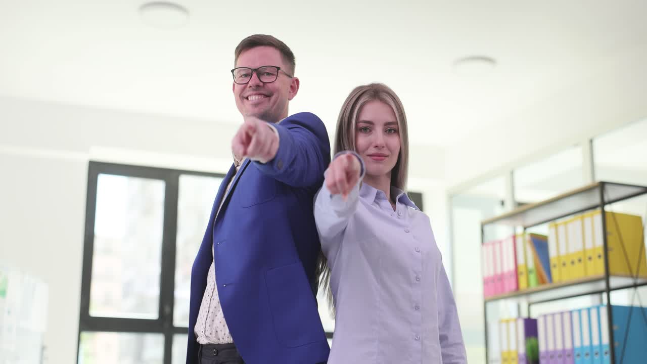 Business team pointing towards camera