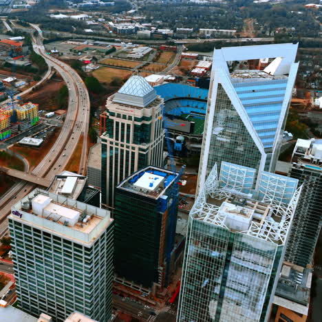 wide multi-lane highway with bridges above dividing the city. drone footage high above the skyscrapers of charlotte, north carolina, usa.