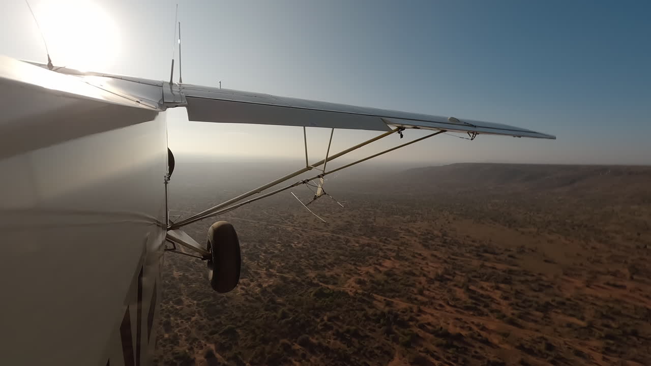 Kleines Flugzeug in Seitenansicht über Sträuchern und Straße