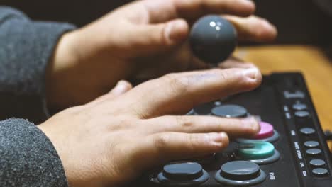 boy who presses the colored button of an arcade pad to play vintage video games