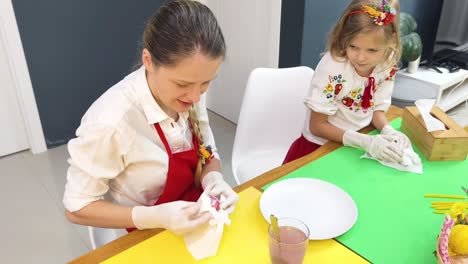madre e hija decorando huevos de pascua