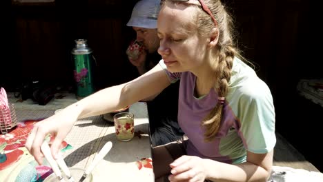 una chica aleja las moscas de la comida en la mesa en un café de nepal.