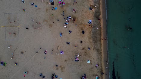 overhead shot of a vibrant beach scene in malta captured by a drone camera showing tourists relaxing and having fun