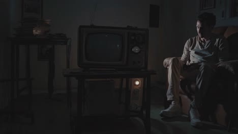 man watching old tv in dark room