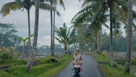 travel couple riding scooter on tropical island with ducks walking over road exploring beautiful travel destination on motorcycle ride in morning mist