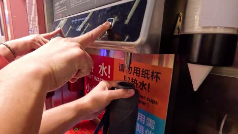 hands operating a water dispenser machine