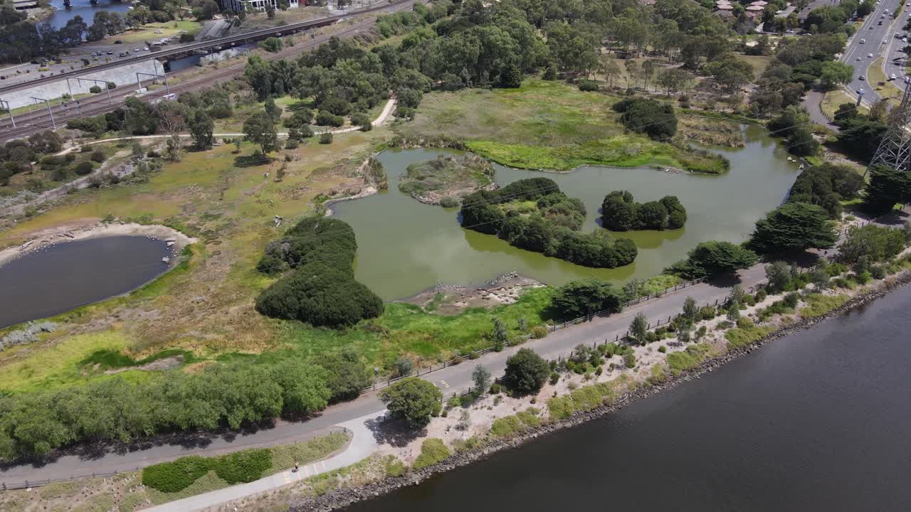 Aerial drone over nature reserve and train line, capturing greenery and birds
