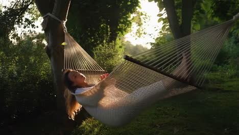woman relaxing in a hammock outdoors during sunset