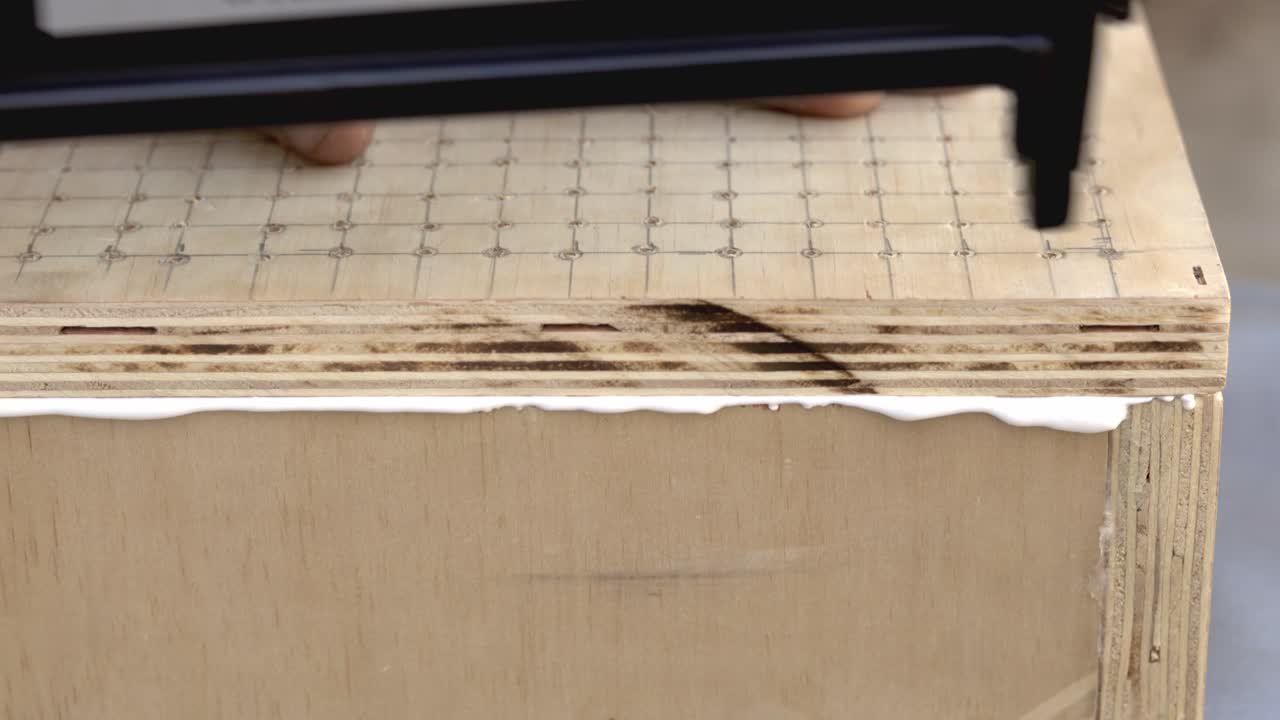 sellado de una caja de madera hecha a mano con clavos de una pistola de clavos