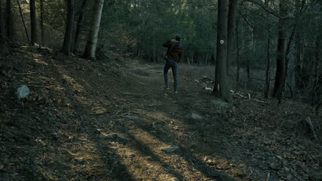 young photographer walks down wooded path