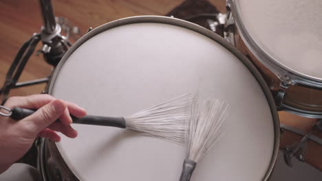 jazz drummer plays snare drum with brushes, overhead, slow motion