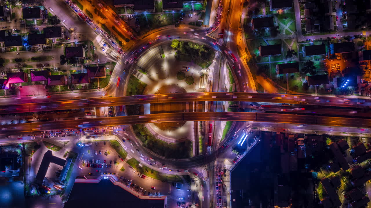 Aerial zenithal hyperlapse showing illuminated roundabout and highway traffic in Santiago de Chile at night