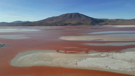 drone reveals stunning red laguna colorada surrounded by volcanoes in bolivia’s south