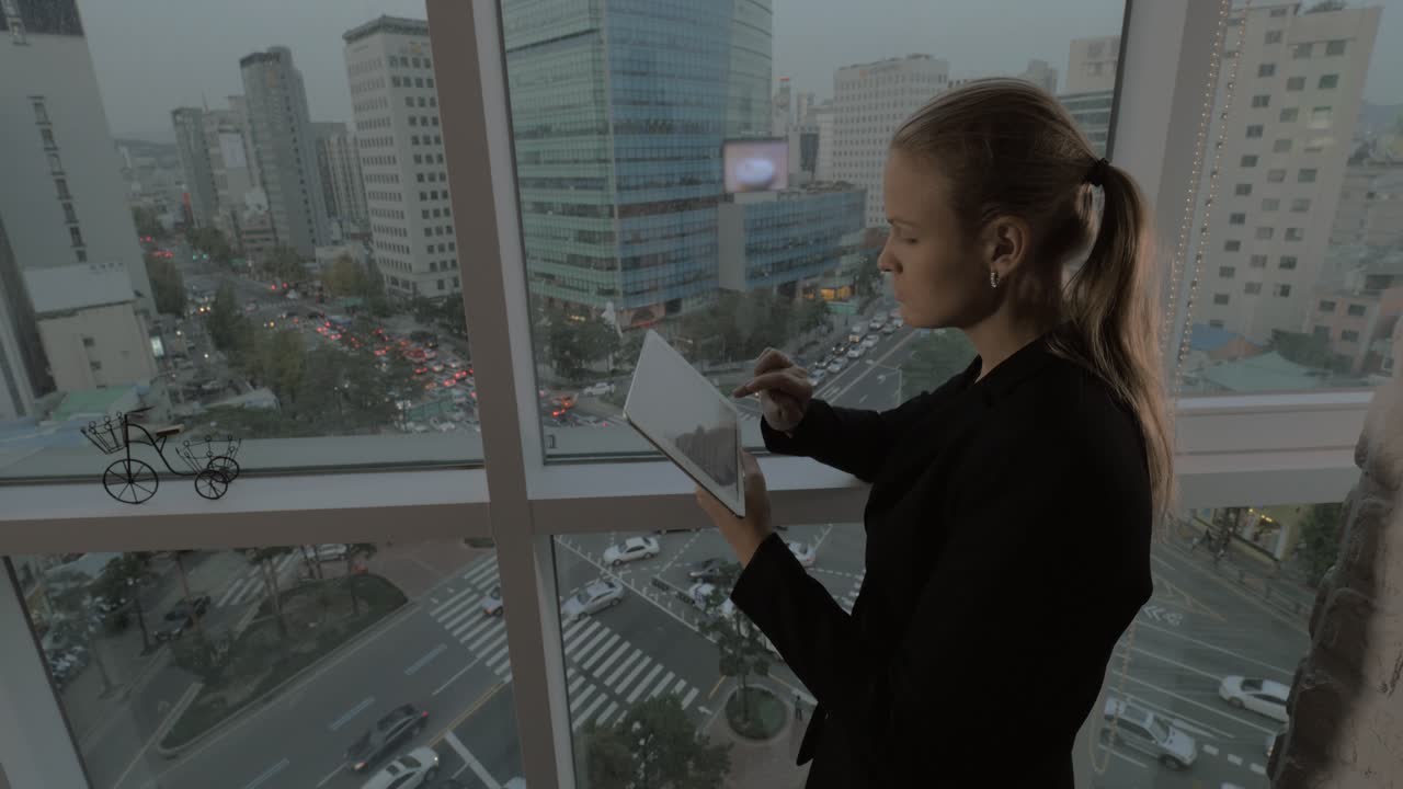 mujer de negocios usando el touchpad junto a la ventana con el paisaje urbano de seúl corea del sur
