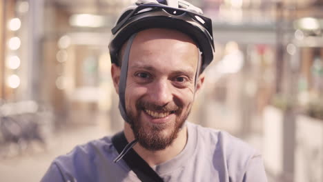 portrait of a smiling bearded rider with a helmet looking directly at the camera