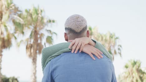 Happy-biracial-couple-embracing-on-promenade,-in-slow-motion