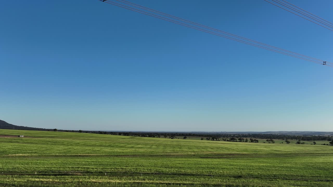 Drone flying under powerlines near sunset