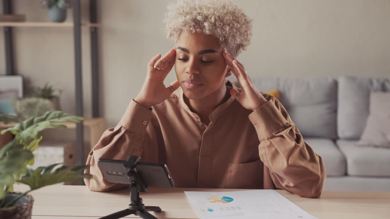African woman blogger recording video for followers on smartphone camera